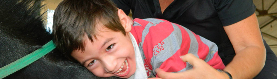 Alumno abrazando al caballo en actividad terapéutica