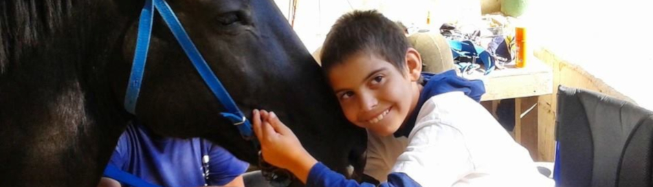 Alumno en contacto cercano con el caballo durante la sesión de equinoterapia